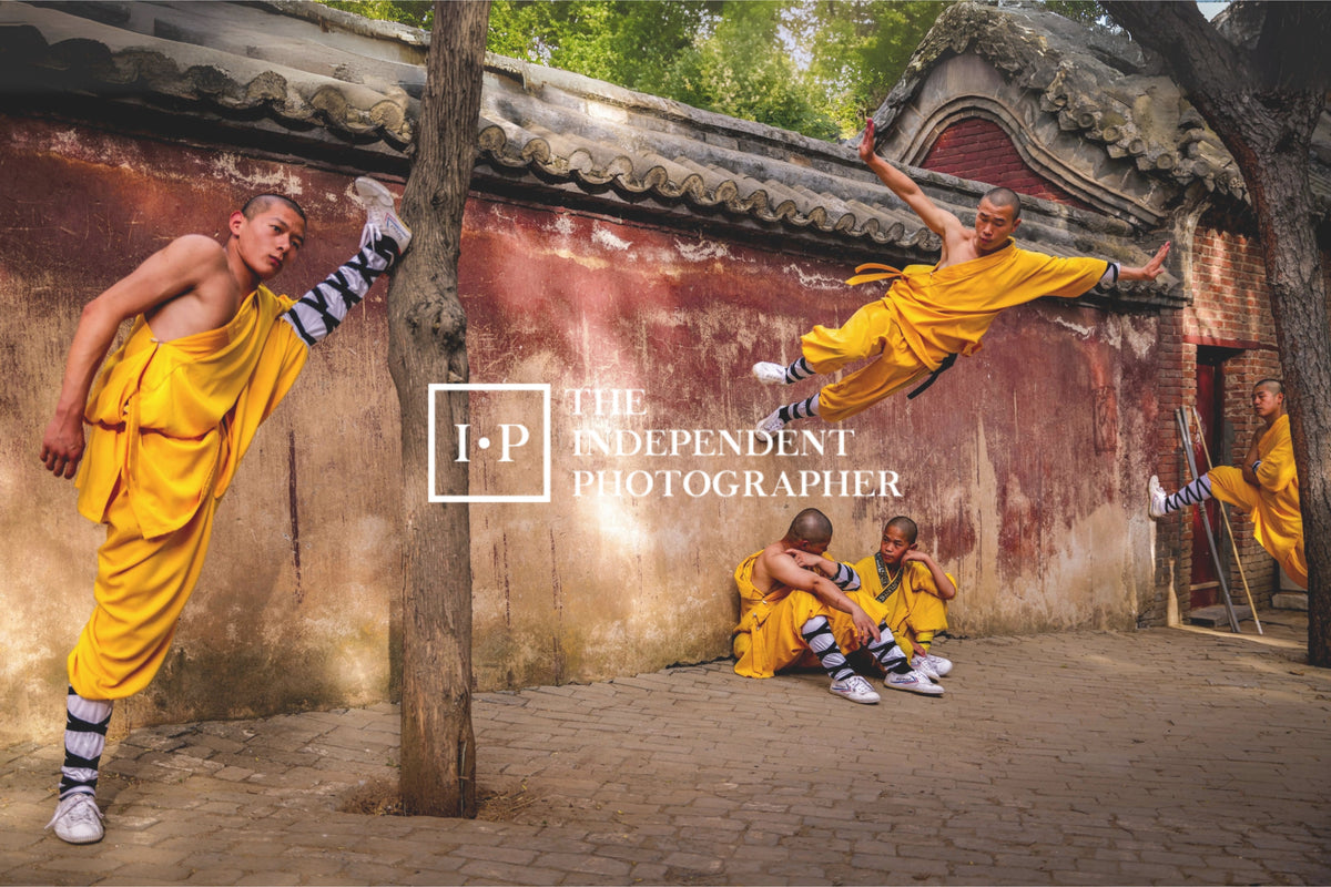 Young monks in yellow robes training beside a worn red wall at Shaolin Monastery, China.
