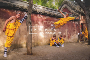 Young monks in yellow robes training beside a worn red wall at Shaolin Monastery, China.