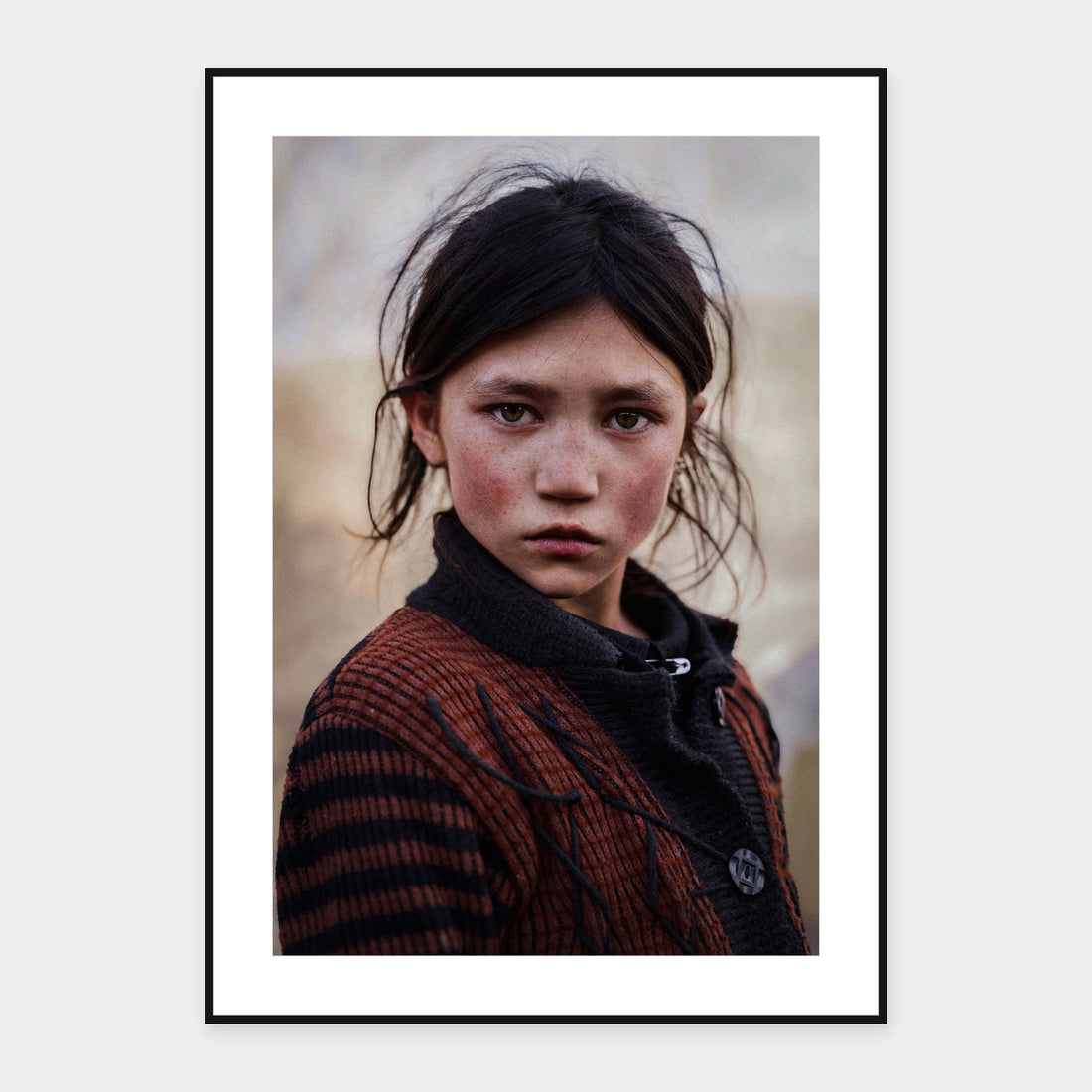 Black-framed display mockup of Afghan Girl II by Laurin Strele; frame shown for illustration.