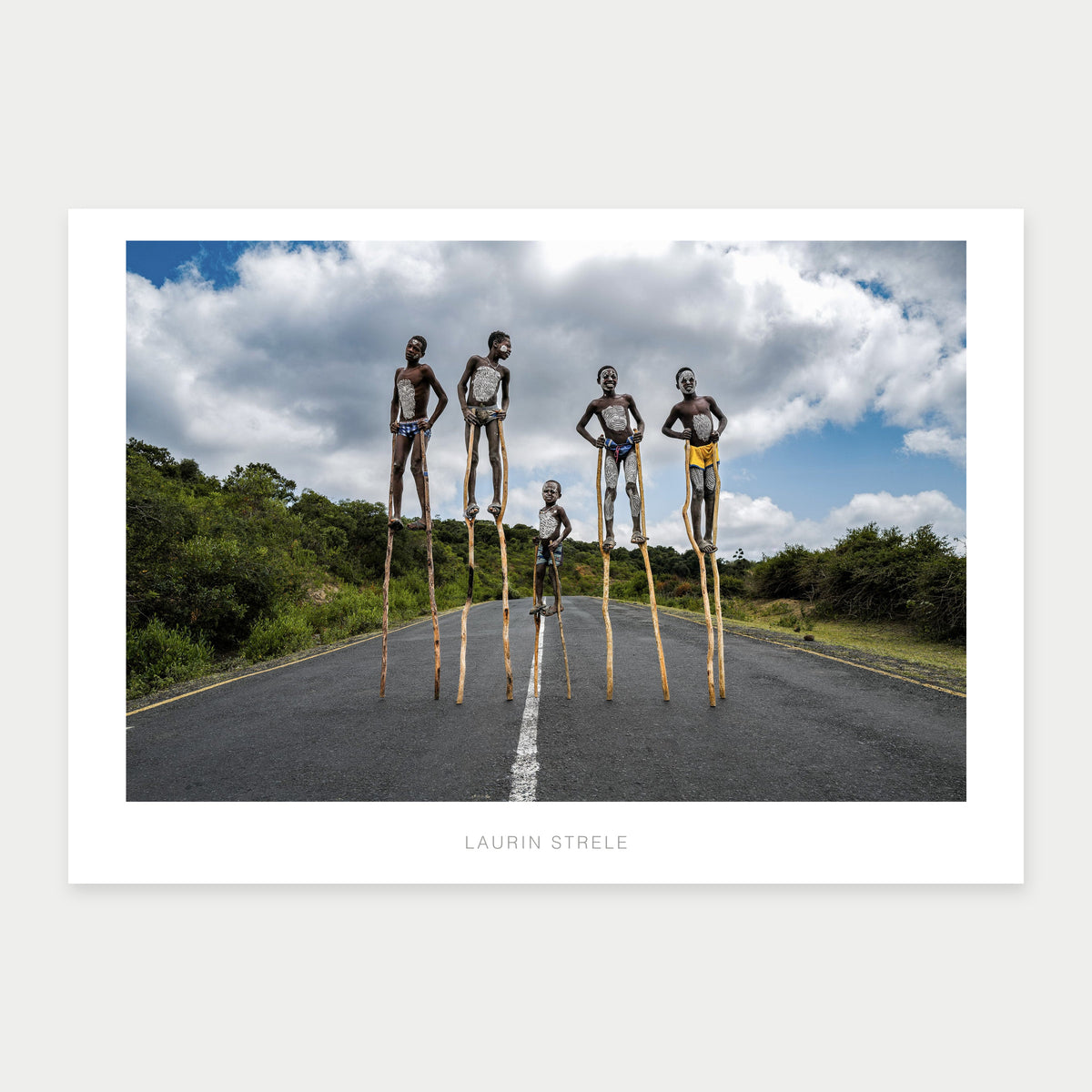 A1 photo poster of Children on Stilts, Ethiopia by Laurin Strele, shown with a white border and light-grey artist name.