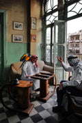 Two friends play backgammon while a parrot perches on one man’s shoulder in Amman, Jordan, October 2024. Photograph by Laurin Strele; image preview for the photo poster.