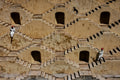 Two men and a dog cross a historic stepwell in Jaipur, Rajasthan, India, 2024. Photograph by Laurin Strele; image preview for the photo poster.