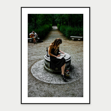 Black-framed display mockup of Reading in Retiro Park by Laurin Strele; frame shown for illustration.