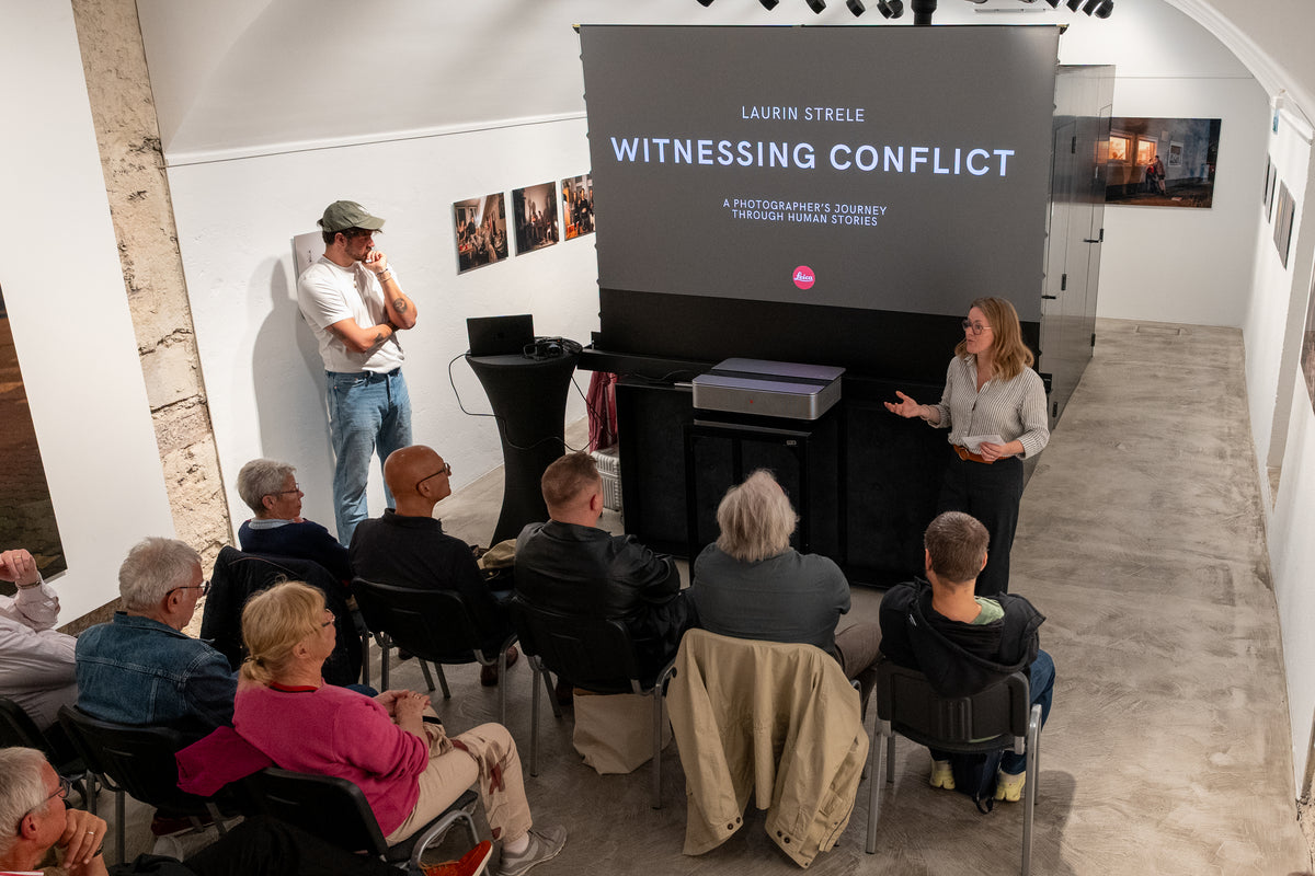 Laurin Strele and a speaker before an audience at a presentation of Witnessing Conflict.